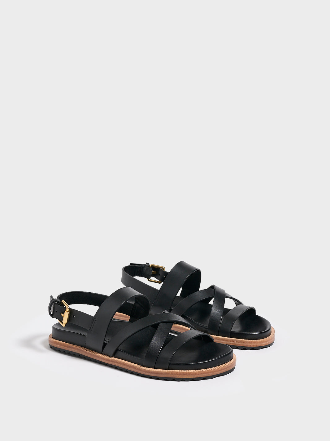 Angle view of a pair of black leather molded footbed slide sandals with an adjustable back strap.