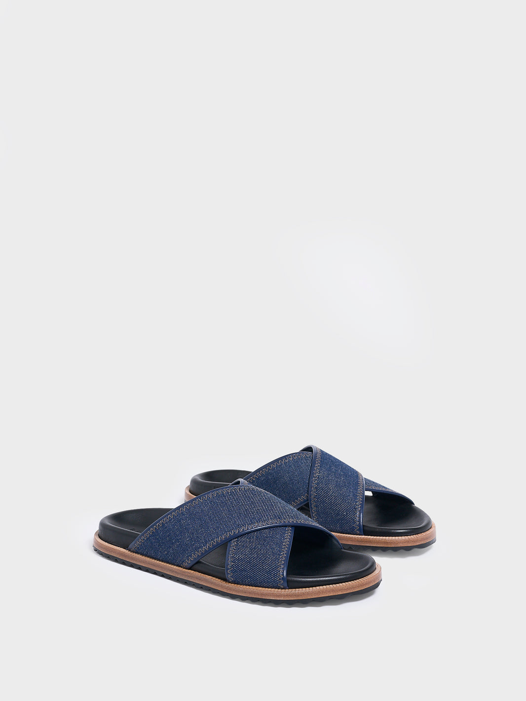Angle view of a pair of navy denim molded footbed slide sandals.