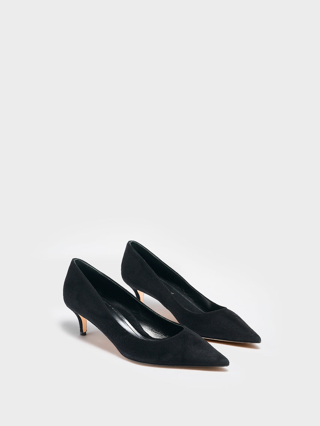 Angle view of a pair of black suede kitten stiletto heel pumps with a pointed toe.