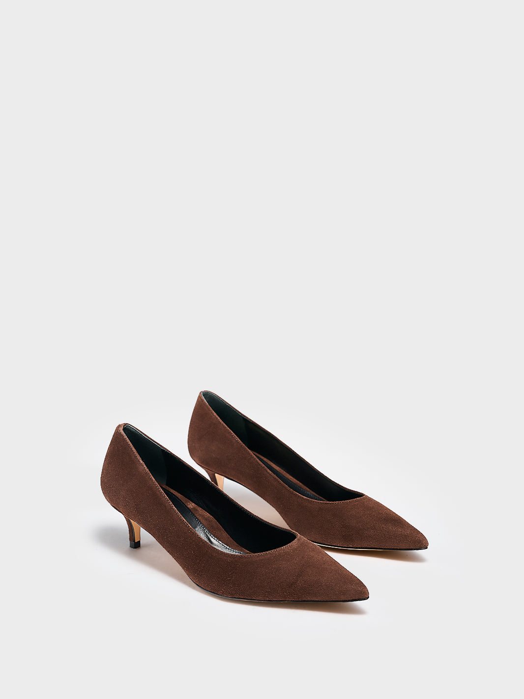 Angle view of a pair of chocolate suede kitten stiletto heel pumps with a pointed toe.