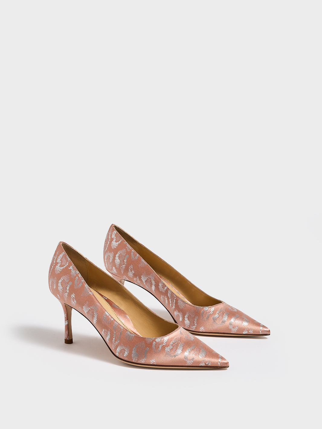 Angle view of a pair of blush leopard silk stiletto heel pumps with a pointed toe.