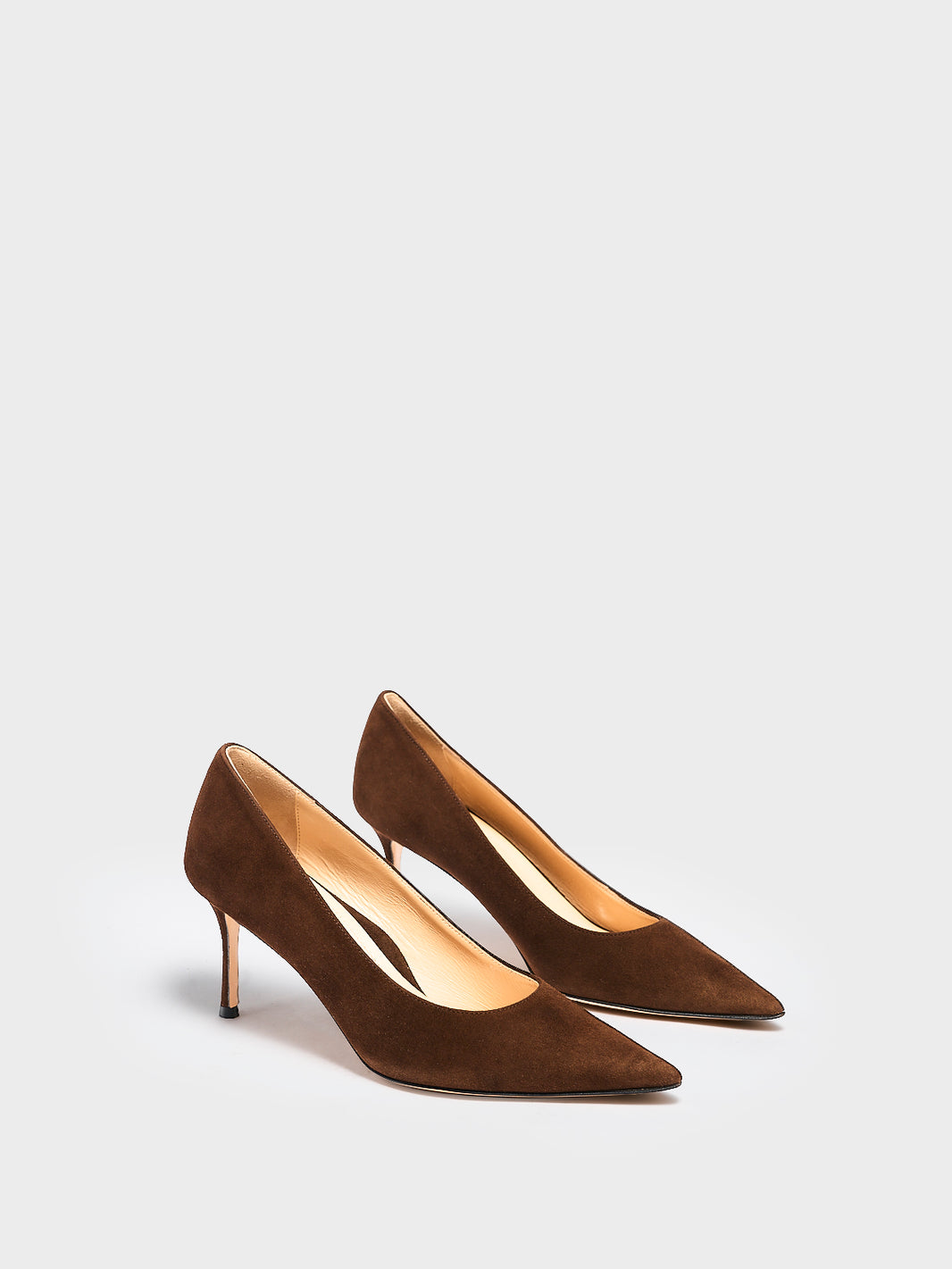 Angle view of a pair of chocolate suede stiletto heel pumps with a pointed toe.