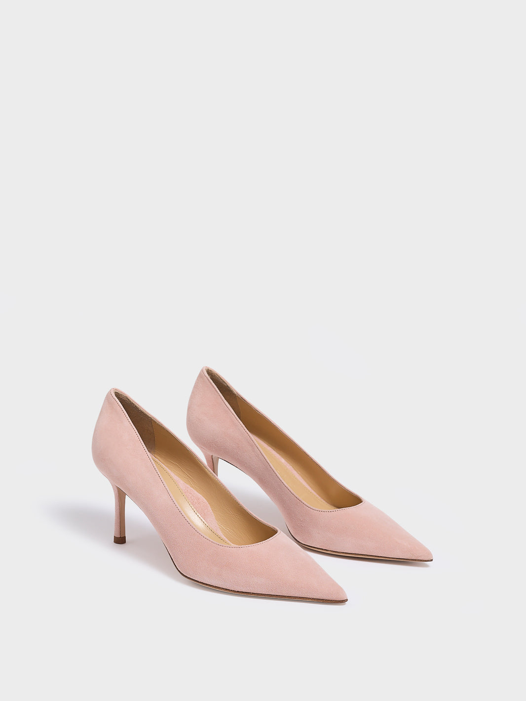 Angle view of a pair of powder suede stiletto heel pumps with a pointed toe.