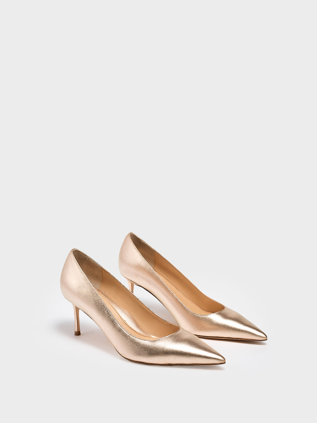 Pair of gold high-heeled shoes on a light gray background