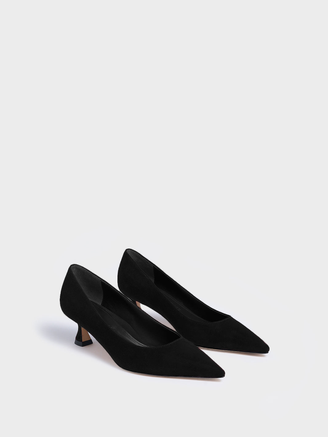 Angle view of a pair of black suede flared kitten heel pumps with a pointed toe.