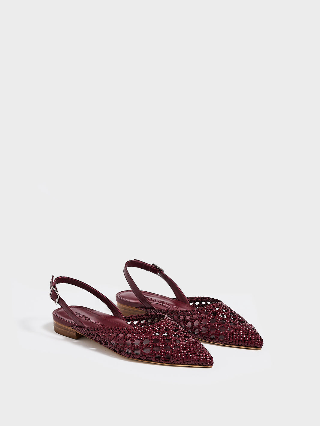 Angle view of a pair of burgundy braided leather slingback flats with a pointed toe