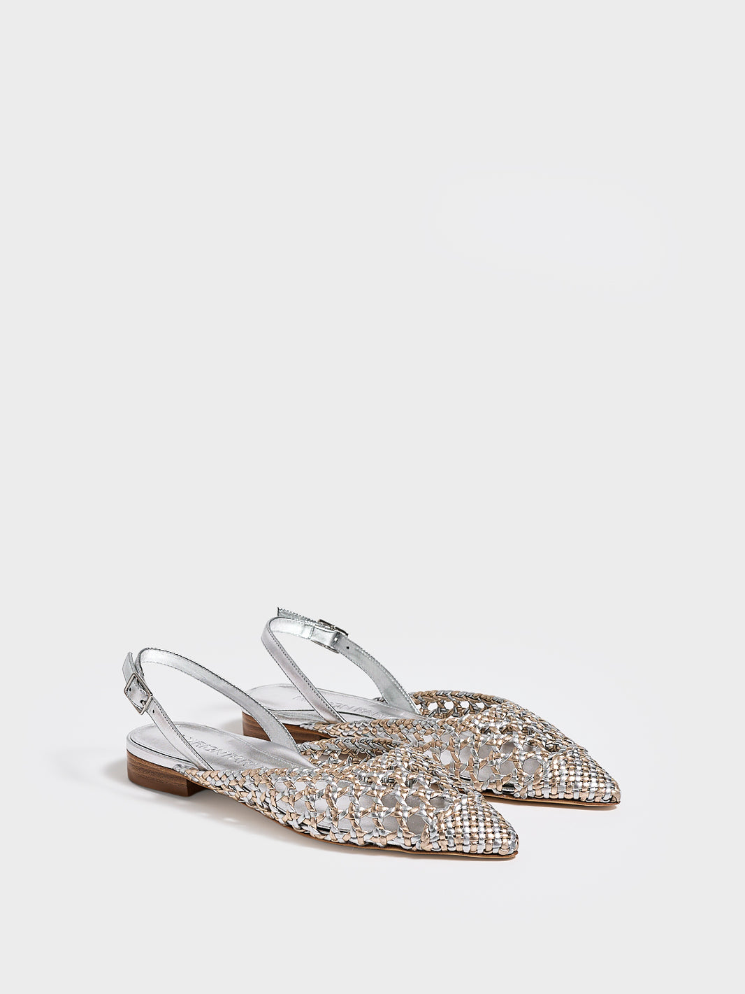 Angle view of a pair of silver and gold metallic braided leather slingback flats. 